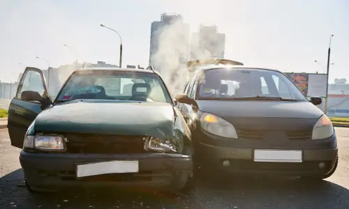 Two dark cars stopped on a flyover after having collided against each other's sides.