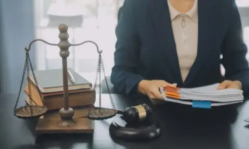 Oakland truck accident lawyer organizing case files at a desk with scales of justice, legal books, and a gavel