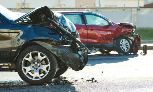 Two heavily damaged vehicles after a San Diego car accident on the road, with front-end damage visible on both vehicles.