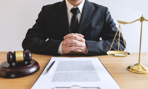 San Diego dog bite lawyer sitting at desk with legal documents, gavel, and scales of justice