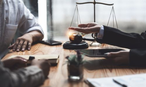 San Diego wrongful death lawyer consulting with clients, with gavel, scales of justice, and legal documents on desk